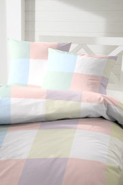 Bettwäsche mit großem Karomuster in Pastellfarben (Hellblau, Rosa, Gelb) und feiner Fischgrät-Struktur, frontal in leichter Schrägansicht auf dem Bett fotografiert