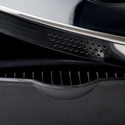 Nahaufnahme eines quadratischen Alugussbräters mit geriffelter Innenfläche und einem Deckel mit Lüftungslöchern.