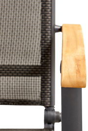 Close-up van een verstelbare fauteuil met houten armleuningen en een bekleding van stof met patroon, gezien vanaf de zijkant.