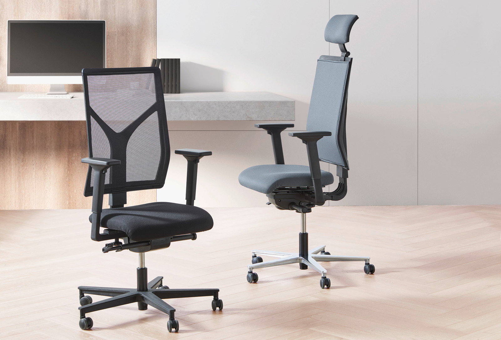 Zwei moderne Drehstühle in einem Büro, einer mit schwarzem Netzrücken und der andere mit grauem Stoffbezug, seitliche Perspektive.