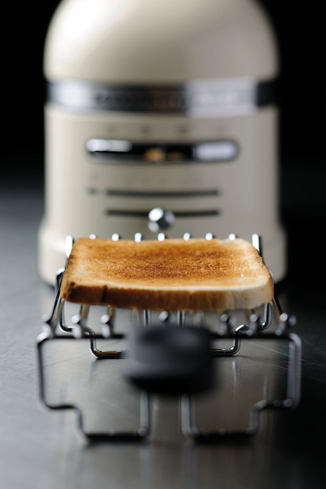 KitchenAid 2-erToaster Nahaufnahme eines 2-er Toasters mit einem frisch gerösteten Toastbrot im Vordergrund. Der Toaster ist in einem eleganten Design gehalten.