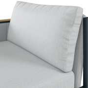 Close-up van een loungebank met een armleuning aan de linkerkant, lichtgrijze stoffen bekleding, zijaanzicht