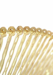 Nahaufnahme eines goldenen, dekorativen Rahmens mit runden Verzierungen, seitliche Perspektive.