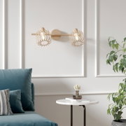 Beige Wandlampe mit zwei offenen Drahtkäfig-Schirmen und sichtbaren Glühbirnen an runder Wandhalterung, frontale Ansicht im Wohnzimmer