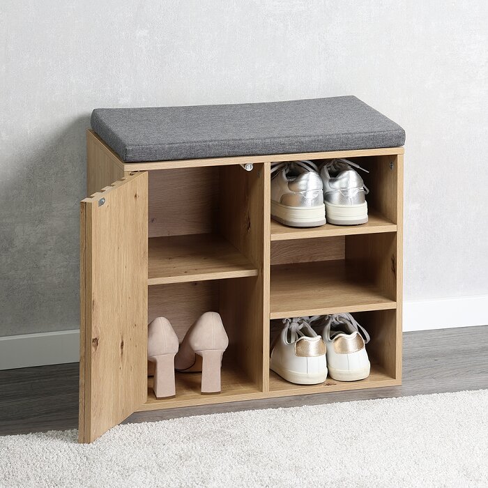 Schoenenkast met zitkussen in licht houtlook met open deur en vakken met schoenen, gefotografeerd schuin van voren in een interieursetting.