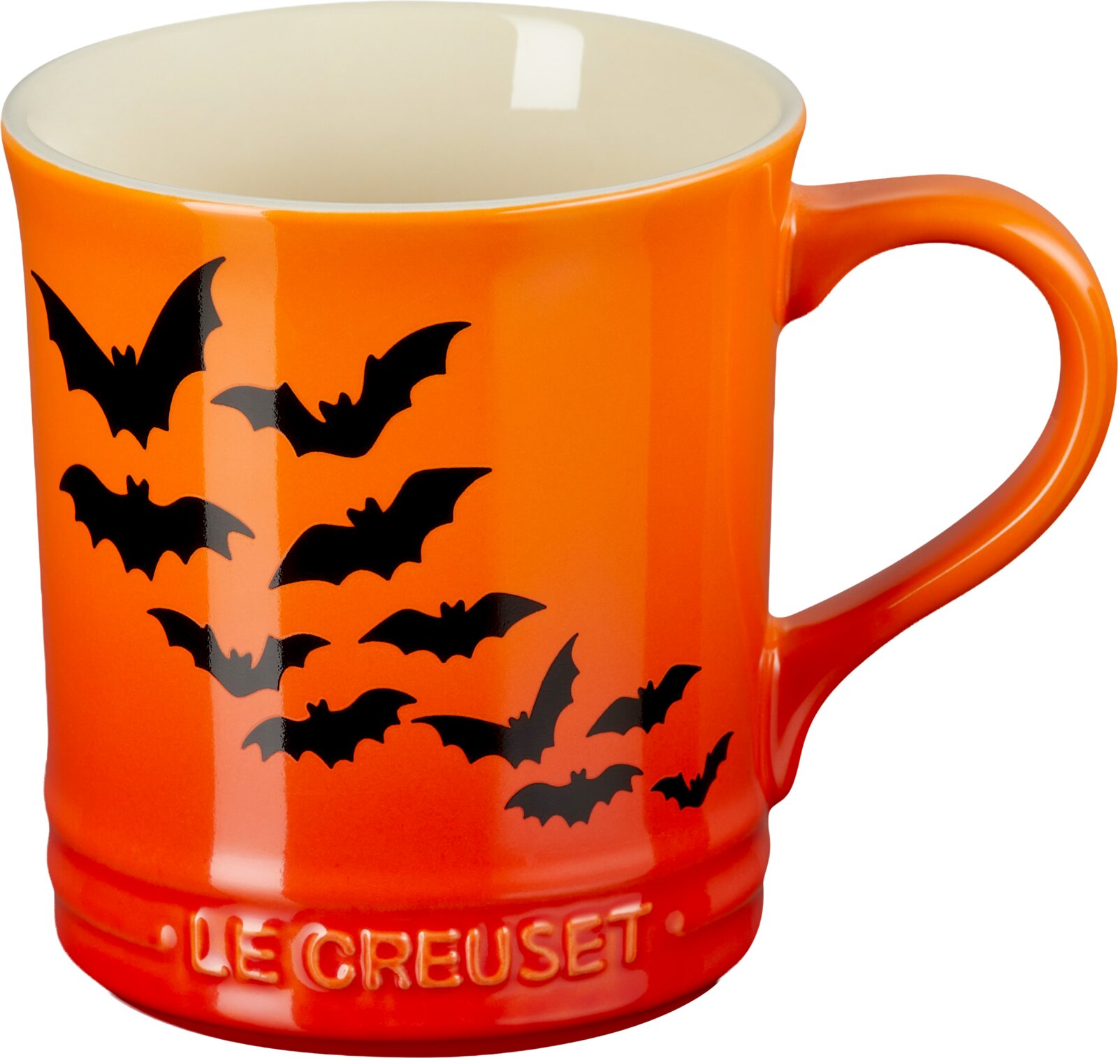 Orange-rote Le-Creuset-Tasse mit schwarzen Fledermausmotiven und cremefarbener Innenseite, in frontaler Seitenansicht leicht von oben