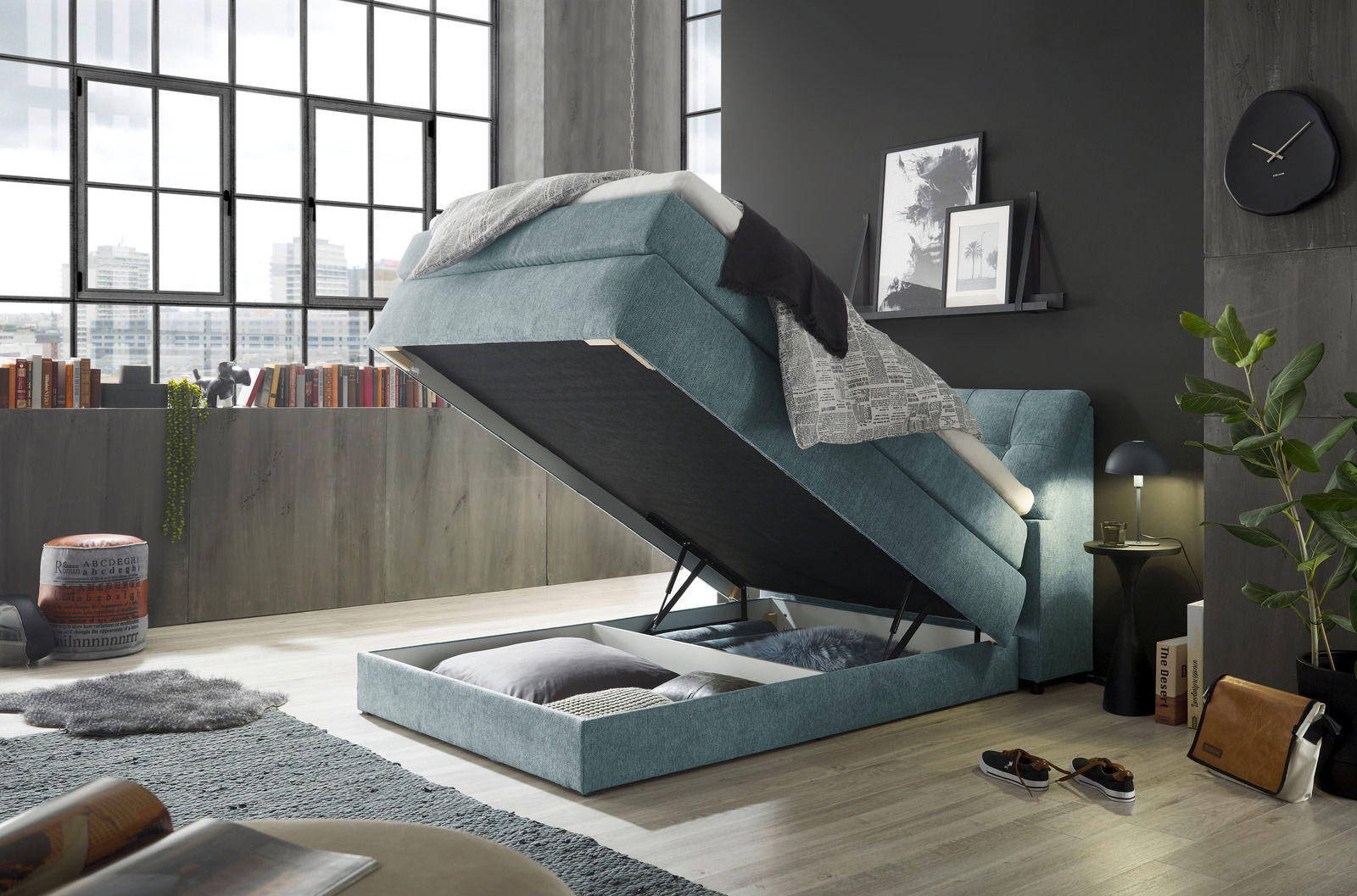 Boxspringbett Set one by Musterring FAIRFIELD in modernem Schlafzimmer, seitliche Perspektive, mit hochgeklappter Matratze und sichtbarem Stauraum darunter.