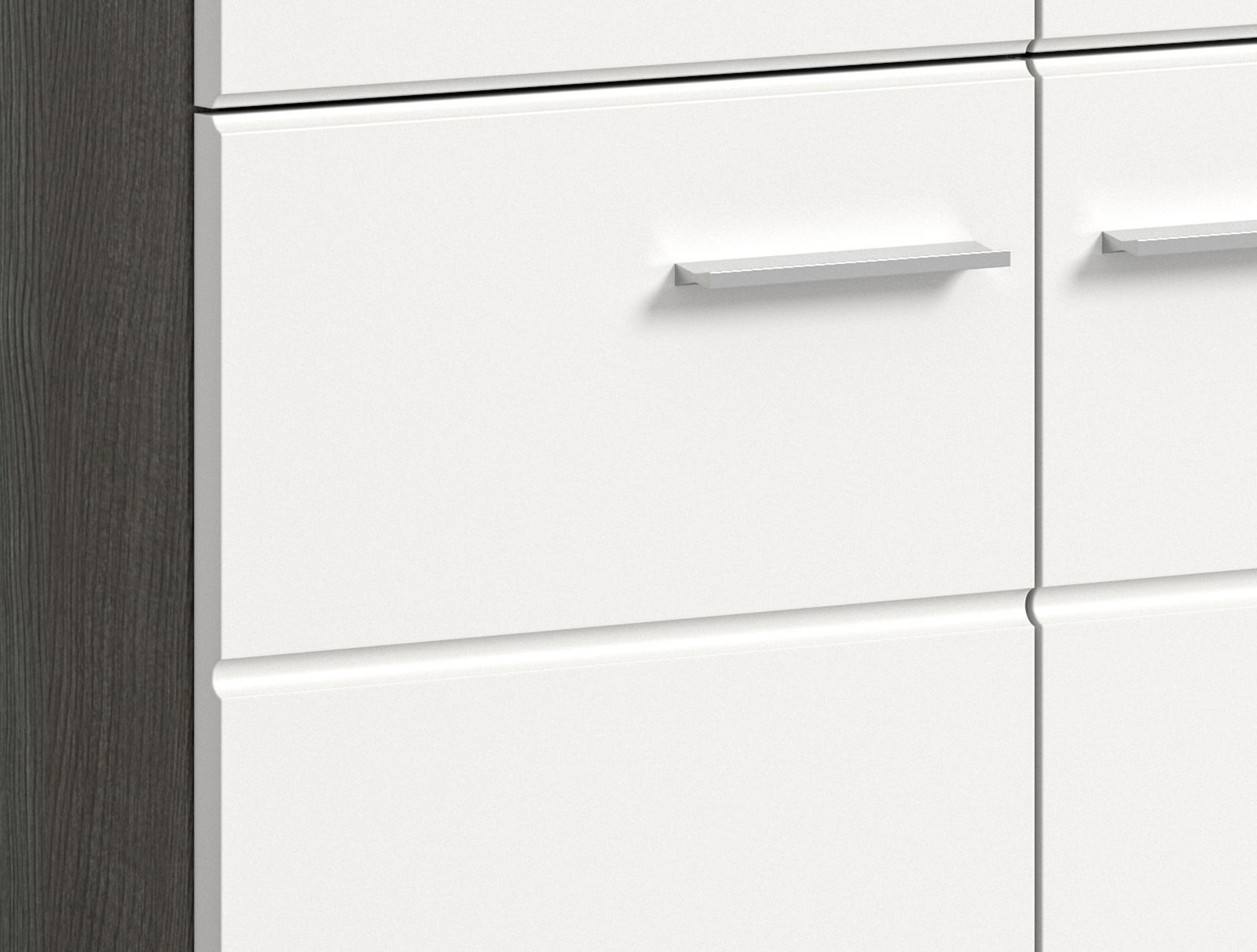 Nahaufnahme einer weißen Schubladenfront mit silbernem Griff, seitliche Perspektive