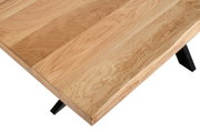 Nahaufnahme eines Esstisches aus Holz mit schwarzem Metallgestell, von oben fotografiert.