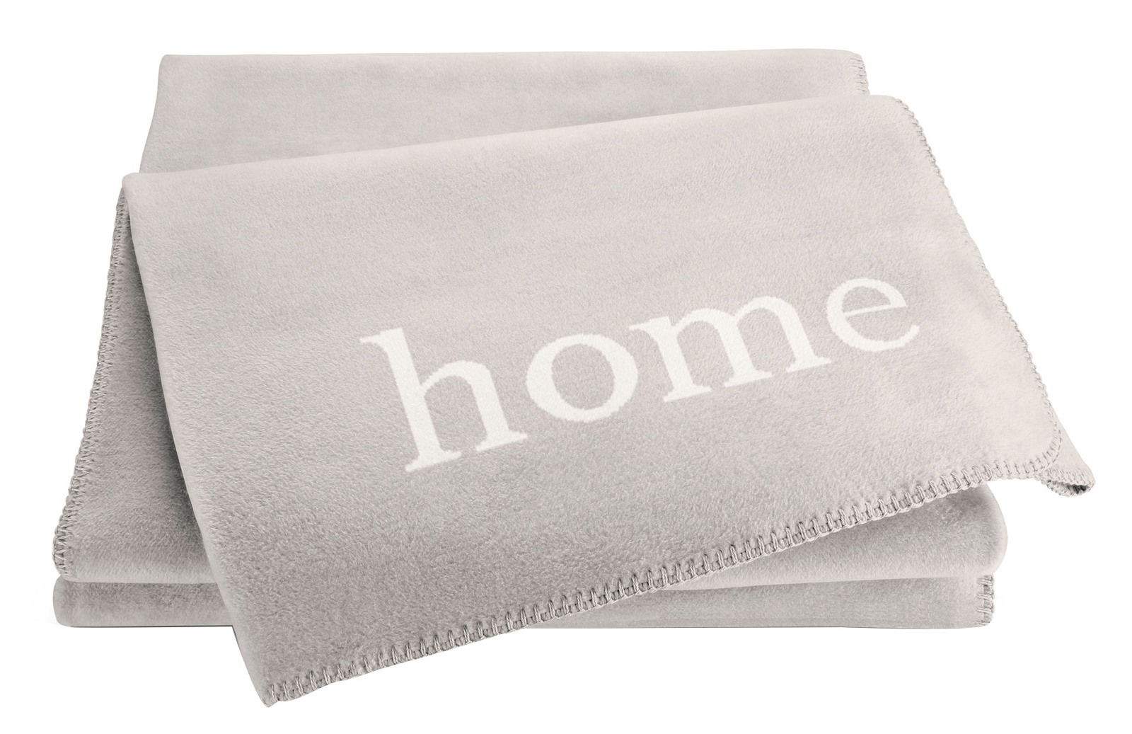 Graue Wohndecke mit dem Wort 'home' in weißer Schrift, aus einer leicht seitlichen Perspektive fotografiert.