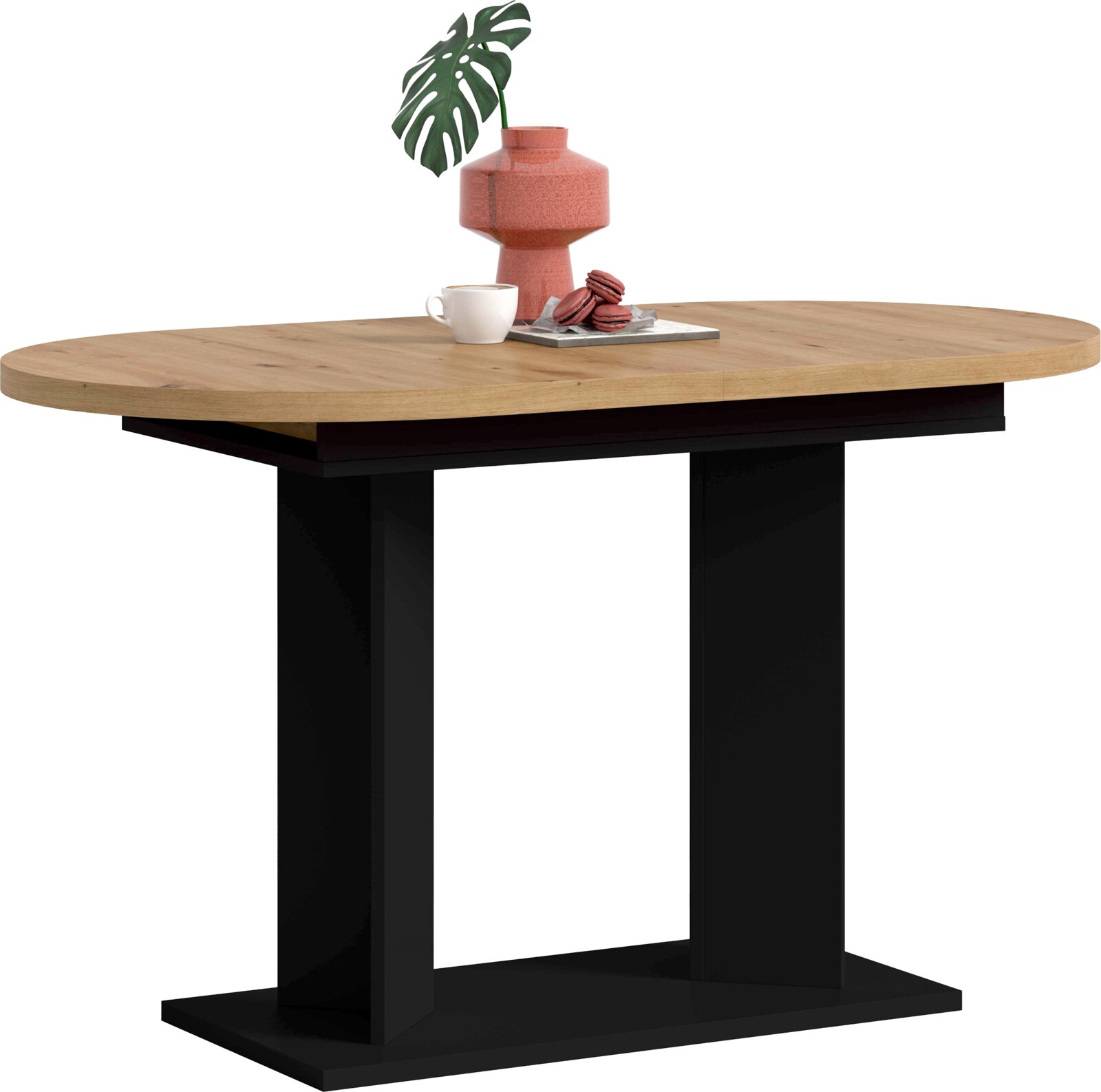 Ovaler Esstisch mit heller Holzplatte und schwarzem Untergestell, frontal in leichter Seitenansicht; auf der Platte stehen eine rote Vase mit Blatt, eine Tasse und Macarons.