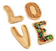 Servierbretter aus Bambus in Form der Buchstaben L, O, V, E, gefüllt mit Snacks, von oben betrachtet.