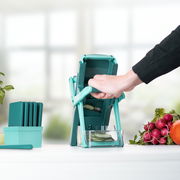 Nicer Dicer Mando, Set 10-tlg., in Benutzung, seitliche Perspektive, mit geschnittenem Gemüse und Zubehör.