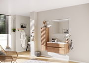 Moderne Badkombination mit Holzoptik, bestehend aus einem Waschtisch mit Schubladen und einem großen Spiegel, seitliche Perspektive.