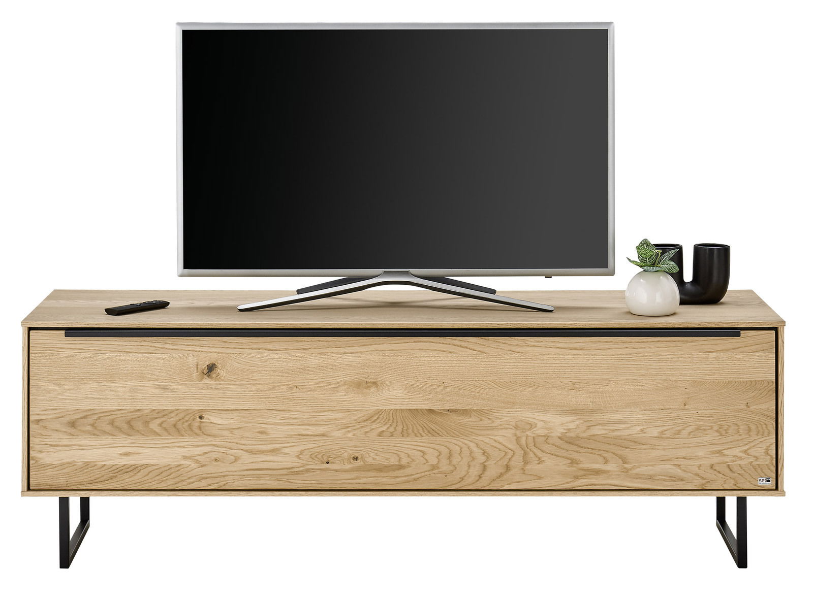 Frontale Ansicht eines kleinen TV-Lowboards aus Holz mit schwarzem Metallgestell, darauf ein Flachbildfernseher und Dekoration.