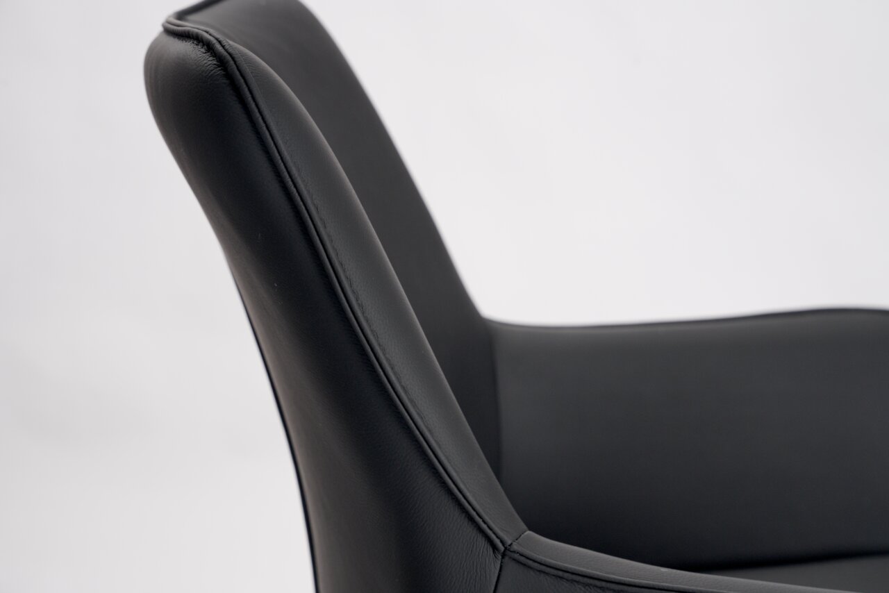 Nahaufnahme eines schwarzen Barhockers mit gepolsterter Rückenlehne, seitliche Perspektive