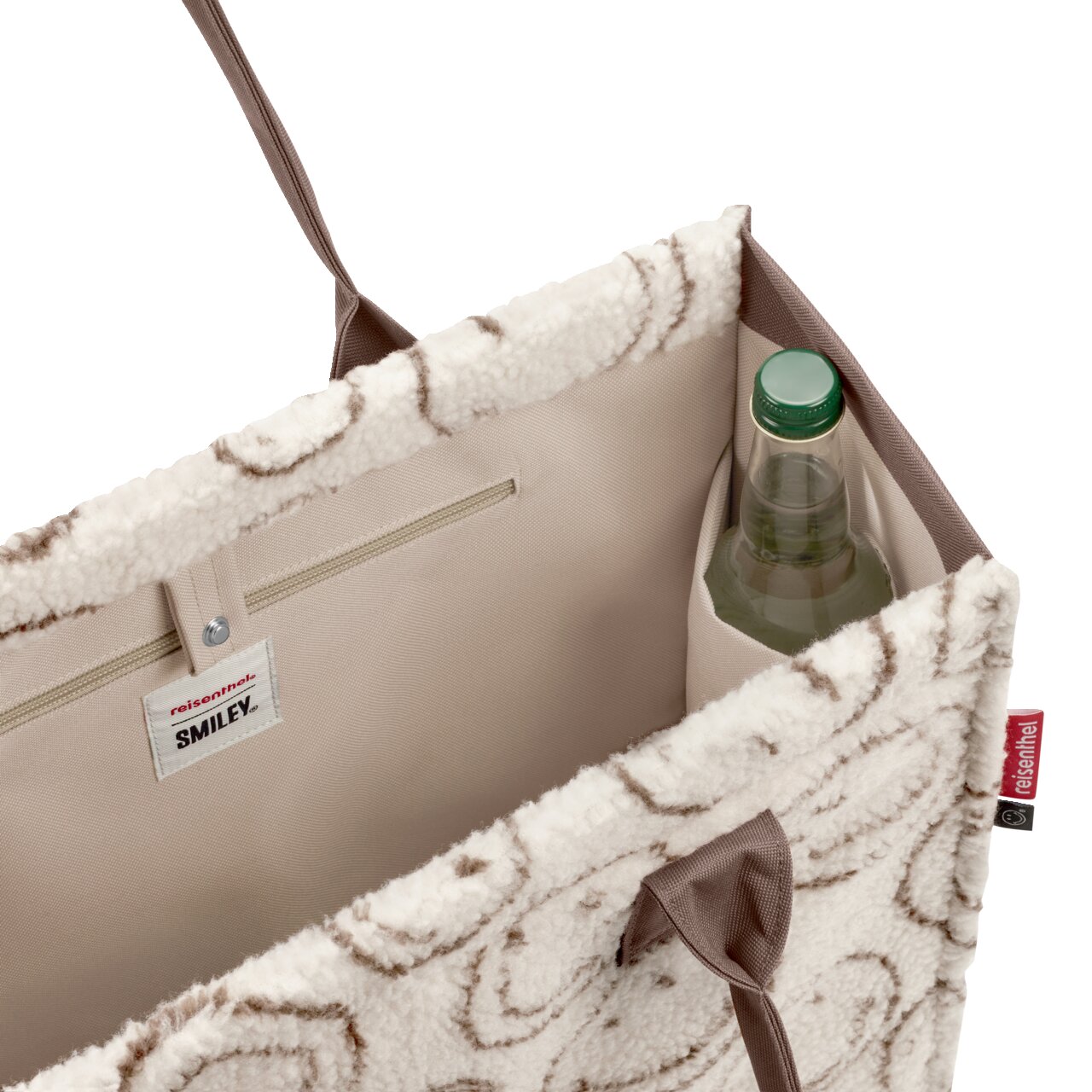 Offene, flauschige Shopper-Tasche in Creme mit braunem Muster und taupefarbenem Innenfutter, Innenfach mit Reißverschluss und Flaschenhalter Ansicht schräg von oben in den Innenraum