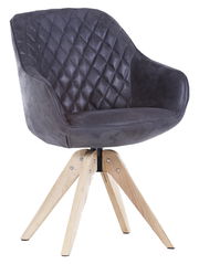 Moderner Stuhl mit gepolsterter, rautenförmig gesteppten Rückenlehne und Sitzfläche in dunklem Stoff, auf hellem Holzgestell. Seitenansicht.