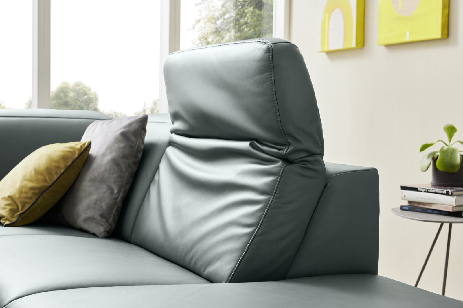 Nahaufnahme eines modernen Ecksofas Musterring MR 1320 mit verstellbarer Rückenlehne und dekorativen Kissen, seitliche Perspektive.