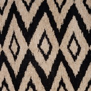 Nahaufnahme eines Ösenschals mit geometrischem Rautenmuster in Schwarz und Beige, von oben betrachtet.