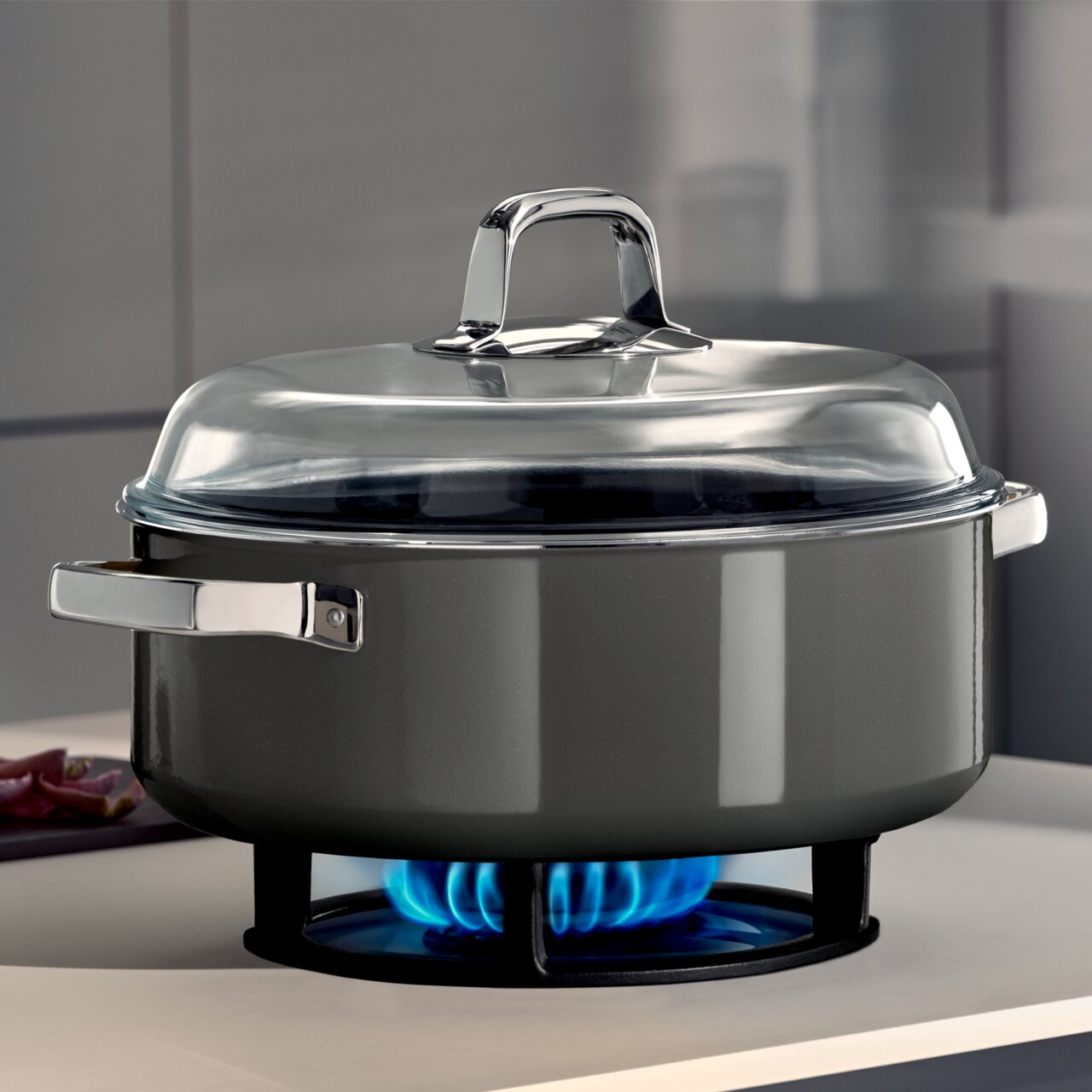 Schmortopf Ø 28cm Platinum auf Herd mit blauer Flamme, seitliche Perspektive