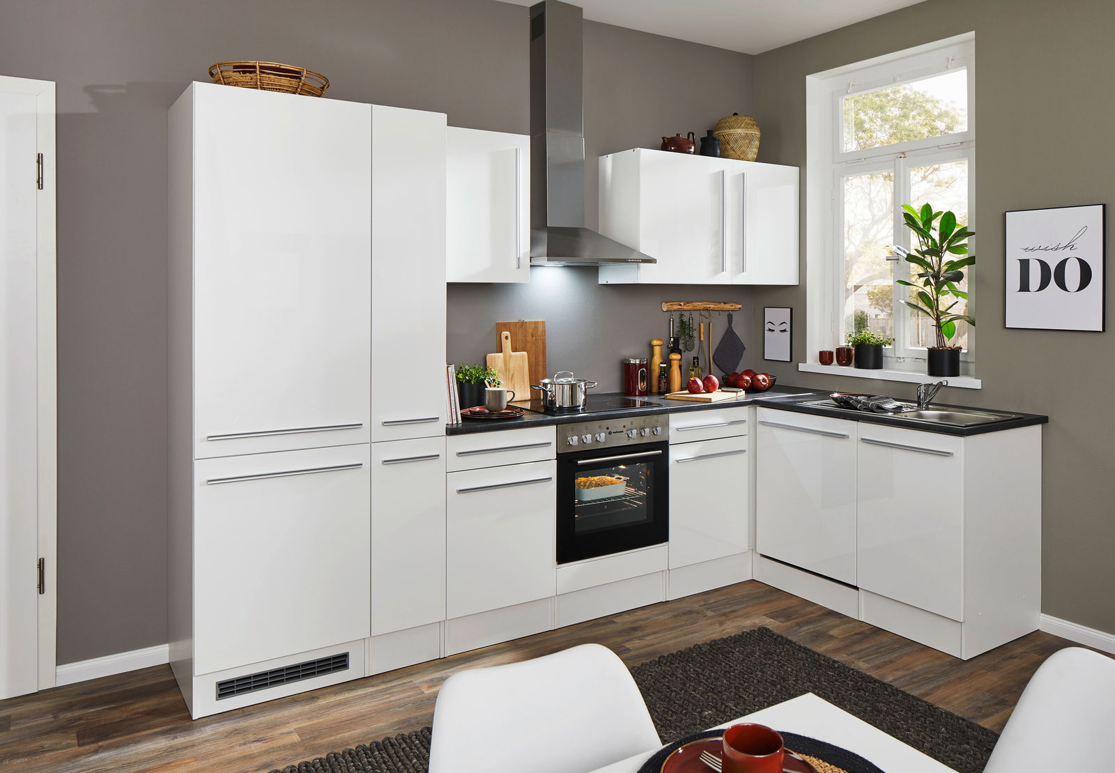 Moderne weiße Küche mit Eckunterschrank, Herd und Dunstabzugshaube, seitliche Perspektive