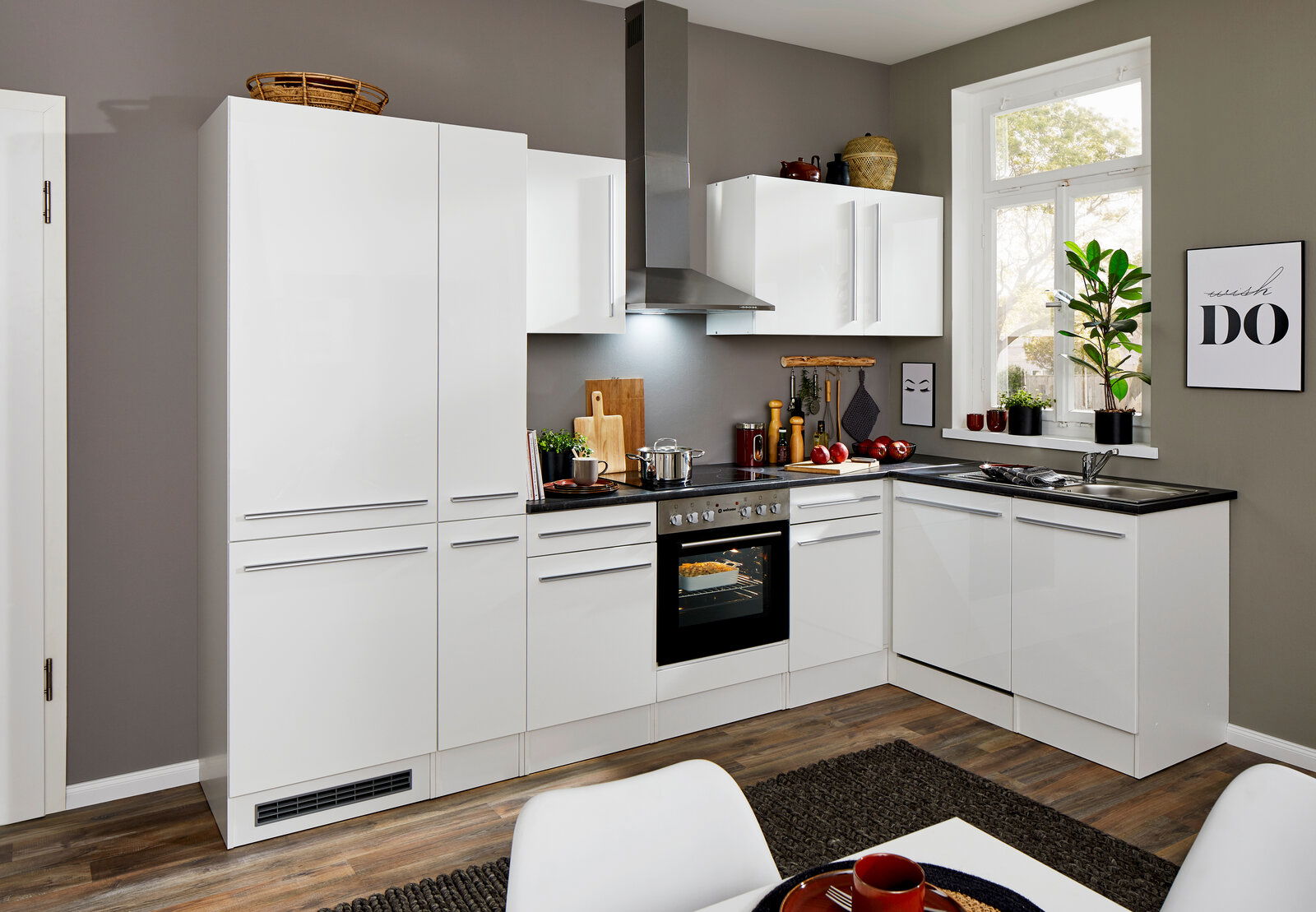 Moderne weiße Küche mit Eckunterschrank, Herd und Dunstabzugshaube, seitliche Perspektive