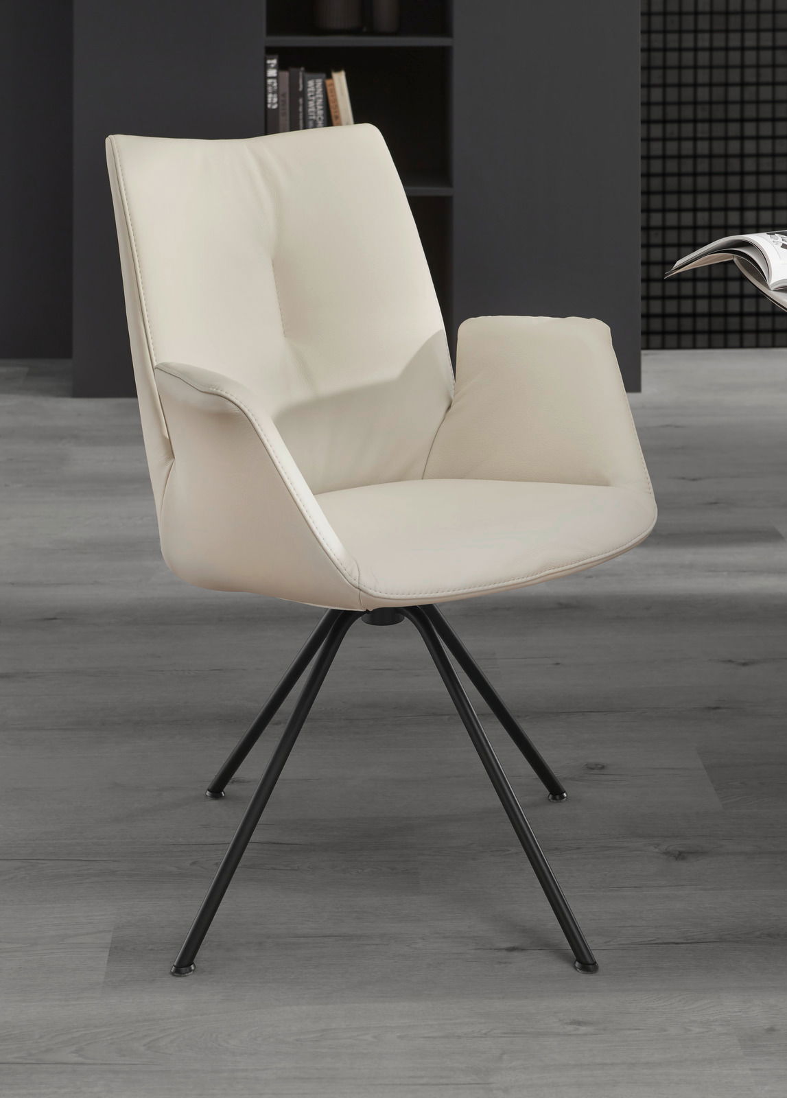 Moderner cremefarbener Sessel mit schwarzem Metallgestell, seitliche Perspektive.