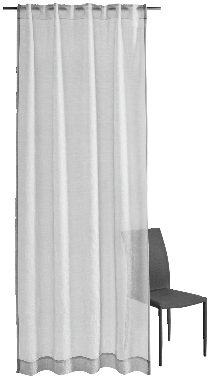 Grauer Vorhang mit Allover-Ornamentmuster, frontal fotografiert, neben einem Stuhl.