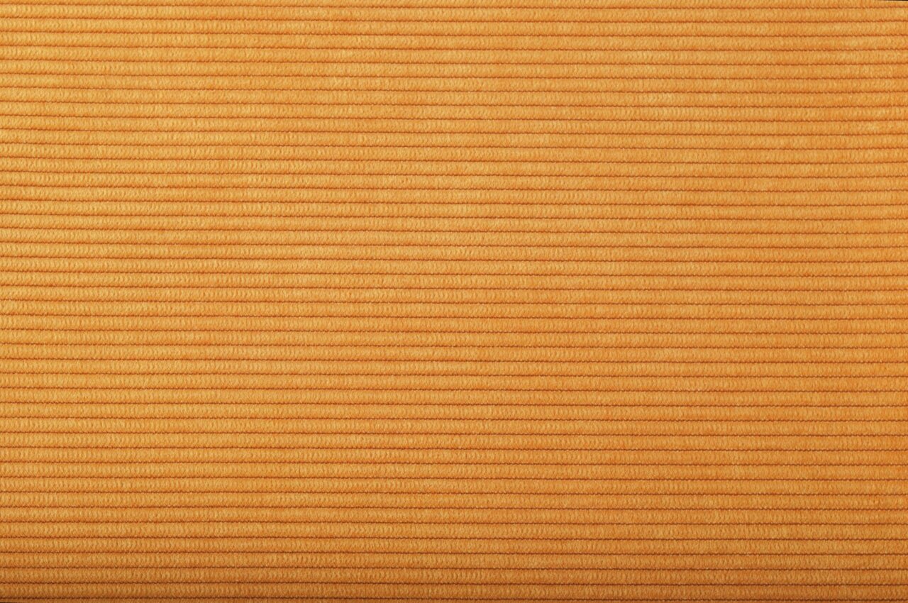 Nahaufnahme eines gelben, gerippten Stoffes in horizontaler Perspektive