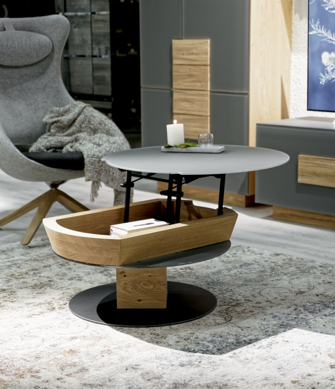 Voglauer Couchtisch VMONTANARA Moderner Couchtisch mit runder, grauer Tischplatte und Holzablage, seitliche Perspektive