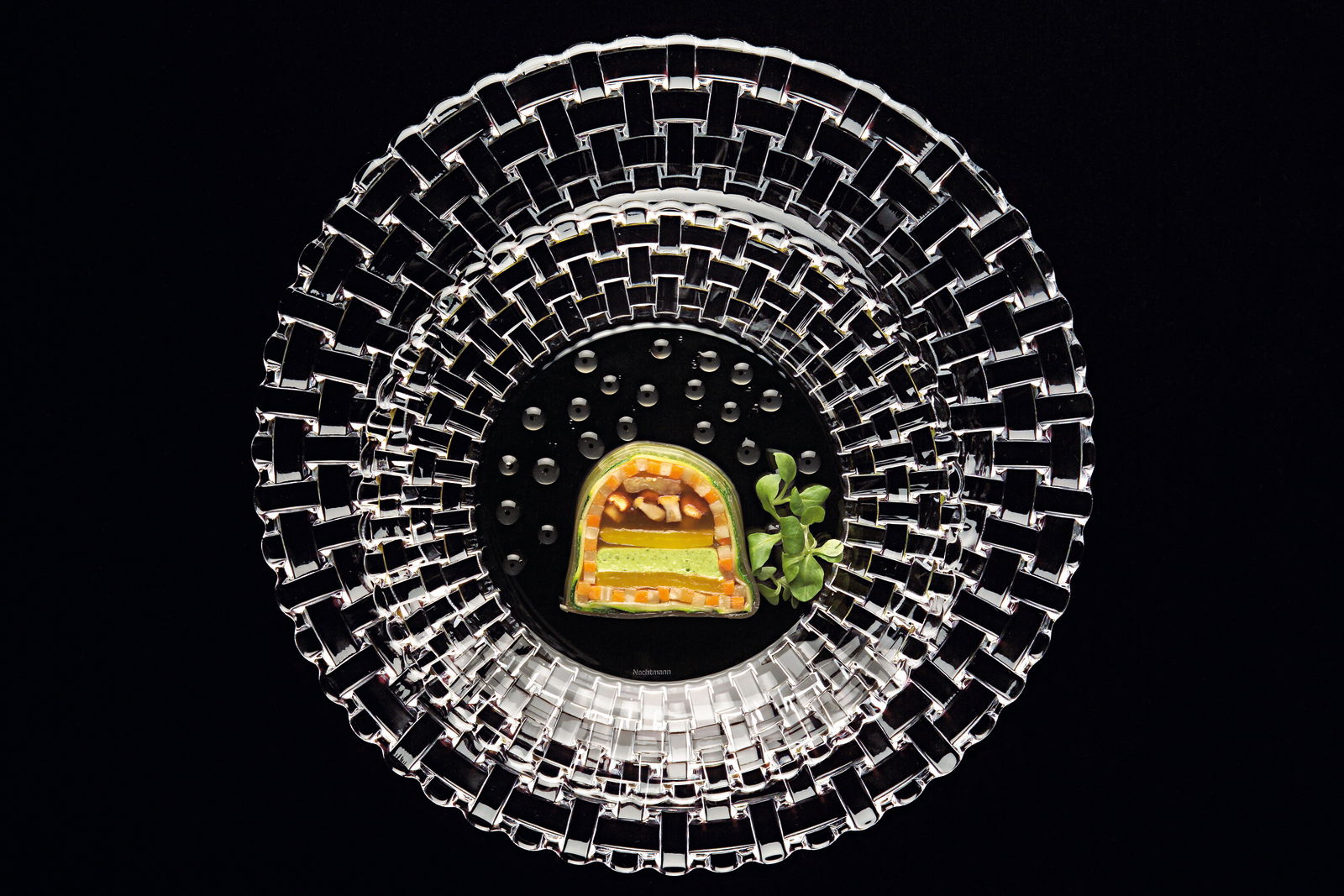 Vogelperspektive auf einen eleganten Platzteller aus der Bossa Nova Kollektion mit einem kunstvoll angerichteten Gericht in der Mitte.