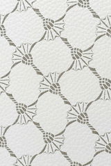 Nahaufnahme eines weißen Pedaleimers mit grauem, geometrischem Muster.