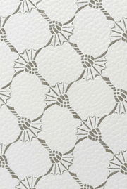 Nahaufnahme eines weißen Pedaleimers mit grauem, geometrischem Muster.