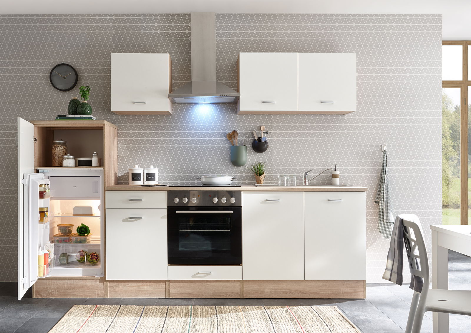 Moderne Küchenzeile mit weißen Schränken und Holzdetails, inklusive Kühlschrank, Herd und Dunstabzugshaube, aus frontaler Perspektive.