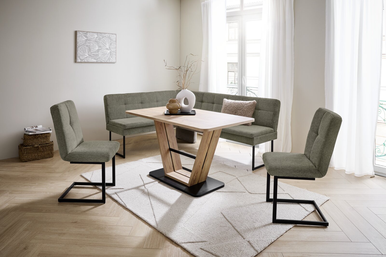 Novel Schommelstoel QUICK Moderne eethoek met hoekbank, eettafel en klapstoelen in een lichte ruimte, gezien van voren.