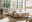 Modernes Schlafzimmer mit einem stilvollen Bett aus Holz und gepolstertem Kopfteil, seitlicher Perspektive. Das Bett ist von natürlichem Licht durch große Fenster umgeben, mit einem Nachttisch und dekorativen Elementen.