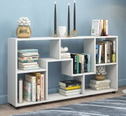 Modernes weißes Bücherregal mit asymmetrischen Fächern, dekoriert mit Büchern, Kerzenhaltern und Pflanzen, frontal aus leichter Seitenperspektive aufgenommen.