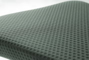 Nahaufnahme eines gepolsterten Sitzes mit wabenförmigem Muster, perspektivisch von oben fotografiert.