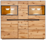 Frontansicht eines Highboards mit Beleuchtung, aus hellem Holz mit zwei Glastüren und integrierter Beleuchtung, die weiße Schalen und Teller hervorhebt.