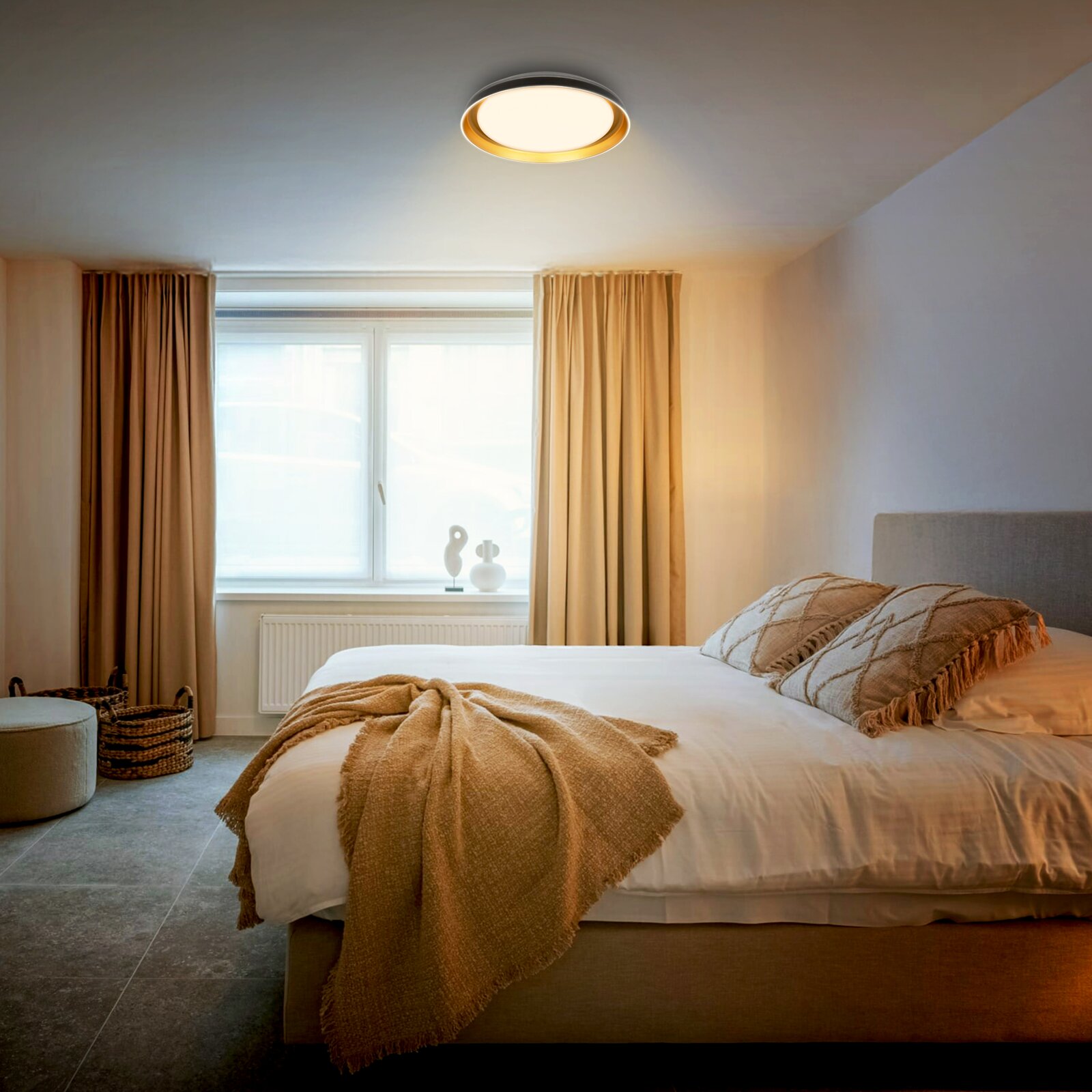 Ronde plafondlamp met warm wit licht en goudkleurige binnenring, van schuin onderen gezien in een sfeervolle slaapkamer