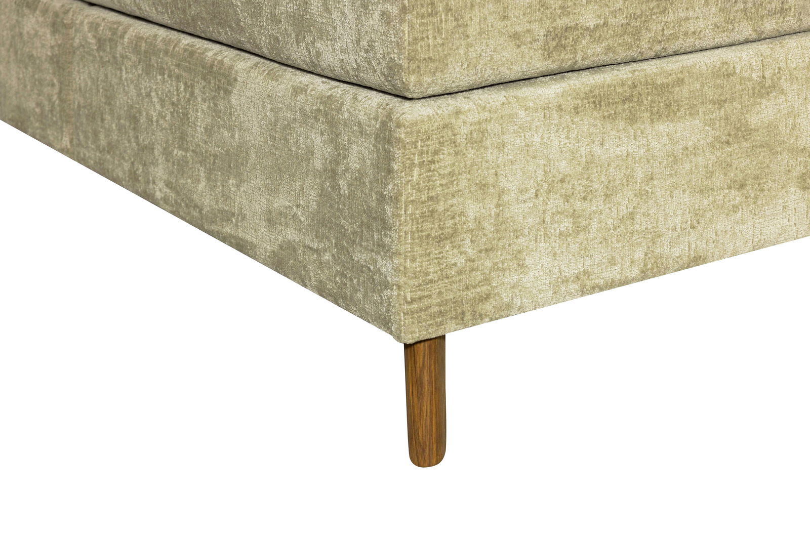 Nahaufnahme eines Boxspringbettes in Beige mit Holzfuß, Perspektive von der Ecke.