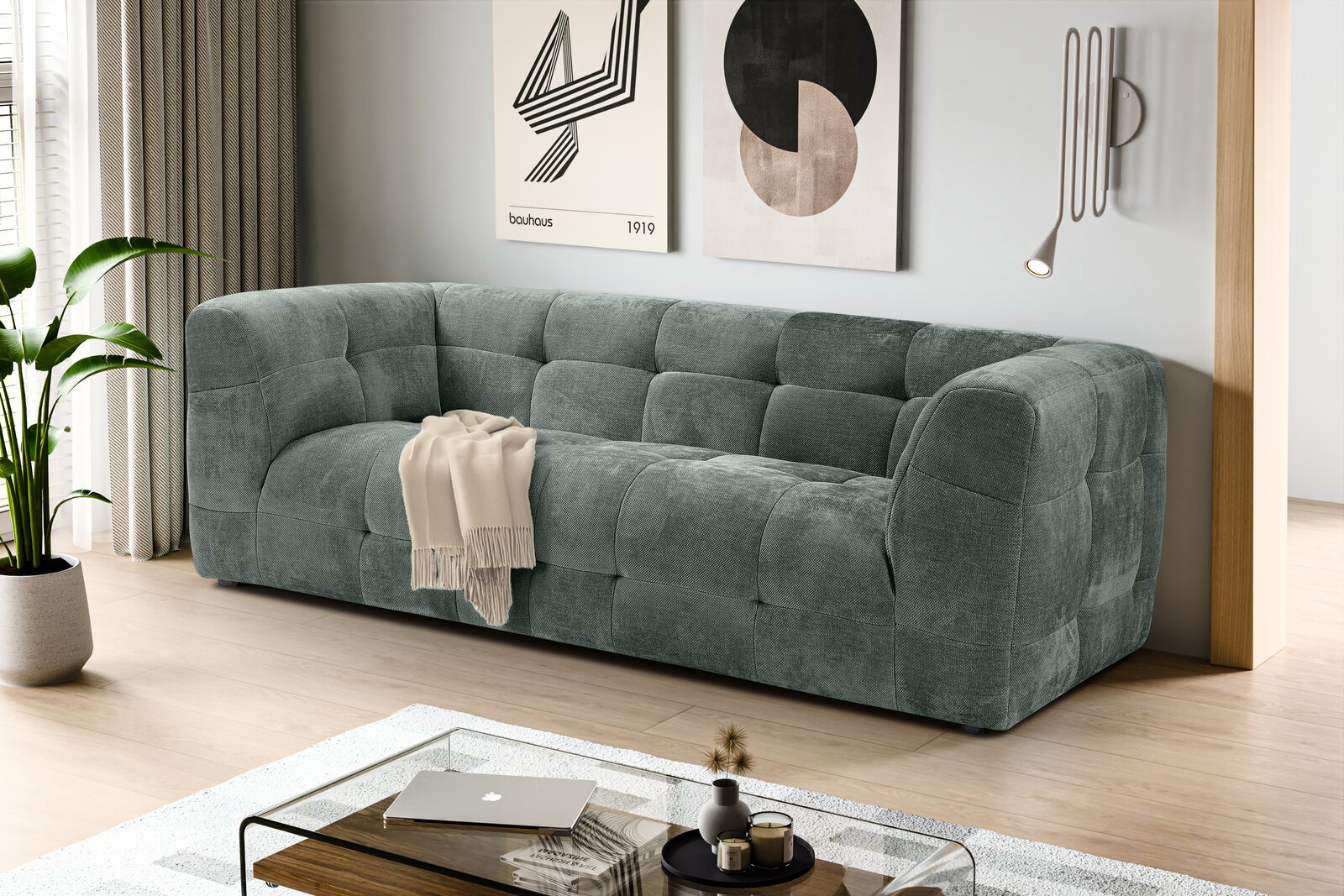 Modernes, gepolstertes 3-Sitzer-Sofa in petrolgrauem Stoff mit Kassettensteppung im Wohnzimmer, schräg von vorne aus leicht erhöhter Perspektive fotografiert