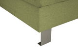 Nahaufnahme einer grünen Sofaecke mit Metallfuß, Perspektive von unten.