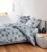 Bettwäsche-Set mit grauem Karomuster auf einem Bett, seitliche Perspektive
