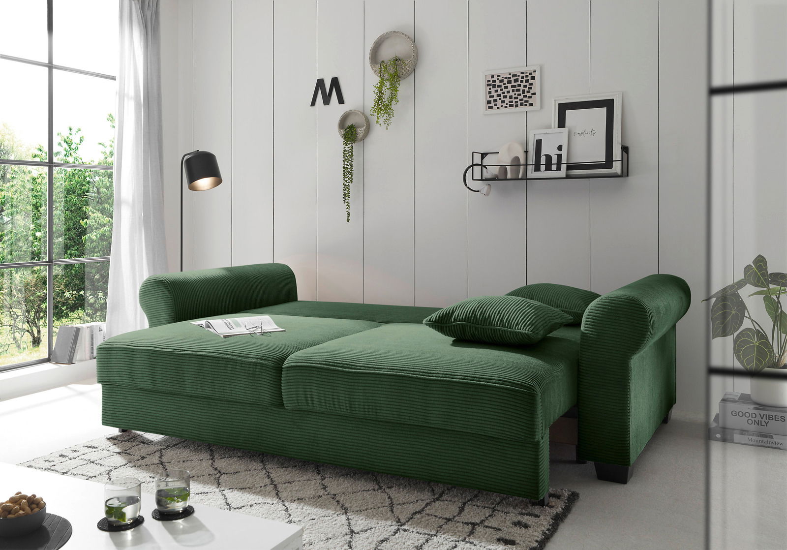 Grünes Funktionssofa in einem modernen Wohnzimmer, seitliche Perspektive