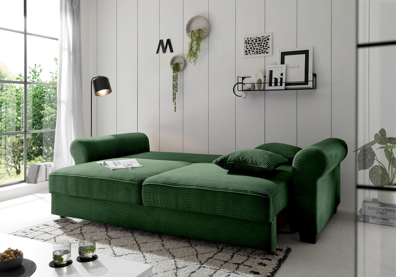 Grünes Funktionssofa in einem modernen Wohnzimmer, seitliche Perspektive