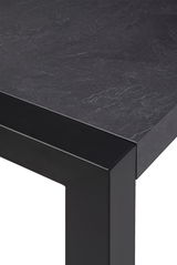 Nahaufnahme eines modernen Esstisches mit schwarzer Steinoptik-Oberfläche und stabilen, schwarzen Metallbeinen, Perspektive von oben.