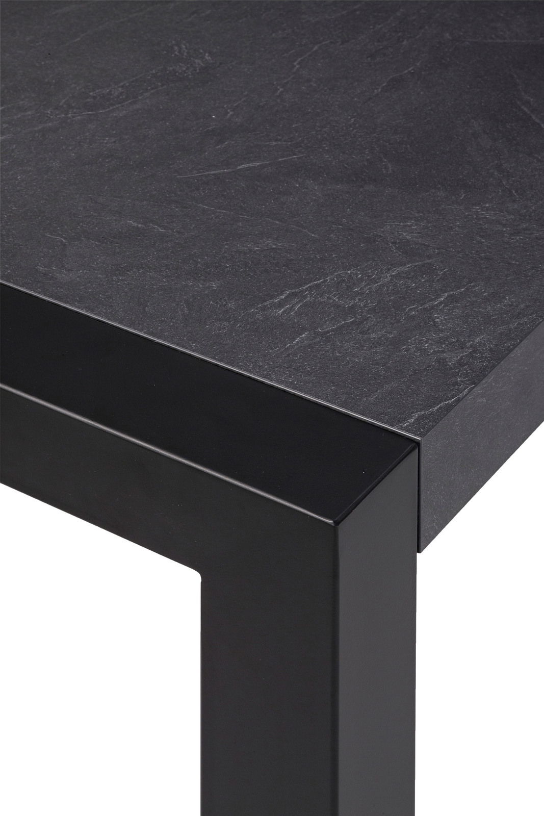 Nahaufnahme eines modernen Esstisches mit schwarzer Steinoptik-Oberfläche und stabilen, schwarzen Metallbeinen, Perspektive von oben.