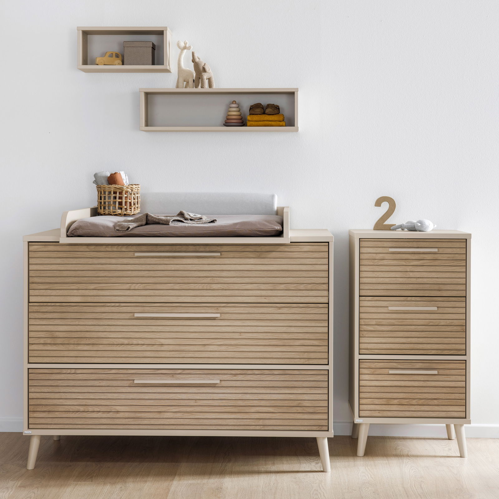 Breite Kommode aus Holz mit Wickelauflage, frontal fotografiert, daneben ein schmaler Schrank mit drei Schubladen.